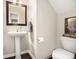 Powder room featuring pedestal sink, wood trim mirror, and decorative artwork at 5751 Evadale Trace, Mableton, GA 30126