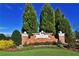 Elegant community entrance sign with beautiful landscaping and tall trees against a bright blue sky at 5751 Evadale Trce # 4, Mableton, GA 30126