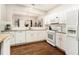 Bright kitchen features white cabinetry, stainless appliances, and hardwood floors at 5751 Evadale Trace, Mableton, GA 30126