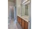 Bathroom with double sinks, wood cabinets, and a doorway leading to another room at 7603 Autumn Breeze, Douglasville, GA 30134