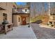 Exterior view of deck and brick patio with outdoor stone fireplace and wooded backyard at 9625 River Lake Dr, Roswell, GA 30075