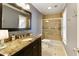 Neutral-toned bathroom featuring dark vanity with granite top and a glass-enclosed shower at 9625 River Lake Dr, Roswell, GA 30075