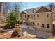 Rear view of home, showcasing a deck, patio, and wooded area at 9625 River Lake Dr, Roswell, GA 30075