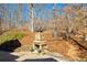 Patio with stone fireplace in wooded backyard at 9625 River Lake Dr, Roswell, GA 30075