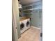 This laundry room has tile floors, a countertop, washer, dryer, and shelving at 9625 River Lake Dr, Roswell, GA 30075