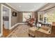 Cozy living room featuring hardwood floors, a plush leather chair, large windows, and easy access to the kitchen at 9625 River Lake Dr, Roswell, GA 30075