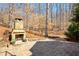 Stone patio with a stone fireplace and wooded background at 9625 River Lake Dr, Roswell, GA 30075