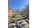 Scenic river view showcasing a building on the left, clear skies, trees and cascading water over rocks at 9625 River Lake Dr, Roswell, GA 30075