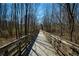 Outdoor shot of a wooden walkway through a wooded area with trees and foliage at 9625 River Lake Dr, Roswell, GA 30075