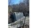 Breathtaking view of a majestic waterfall with rocky terrain and lush trees in the background under clear skies at 9625 River Lake Dr, Roswell, GA 30075