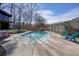 An inviting in-ground pool surrounded by concrete, an outdoor table with chairs, and a rustic fence for privacy at 1251 Oakdale Rd, Canton, GA 30114