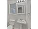 A well-lit bathroom with white pedestal sink and a window providing natural light at 1835 Big Haynes Ct, Grayson, GA 30017