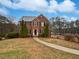 Inviting brick home featuring lush evergreens, manicured landscape, and a stone walkway to the entrance at 1835 Big Haynes Ct, Grayson, GA 30017