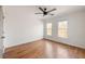 A bright bedroom featuring hardwood floors, two windows, a fan and neutral paint at 624 3Rd Ave, Decatur, GA 30030