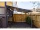 Backyard carport with black metal frame and transparent roof, complemented by a wooden fence and landscape at 624 3Rd Ave, Decatur, GA 30030