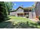 View of the stone house featuring a lush green backyard and staircase to the upper deck at 716 Counsel Ne Dr, Marietta, GA 30068