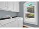 Convenient laundry room with front load machines, lots of light, and ample storage at 716 Counsel Ne Dr, Marietta, GA 30068