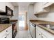 Galley kitchen featuring granite countertops and a view into a sunny living space at 1280 W Peachtree St Nw # 3208, Atlanta, GA 30309