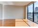 Cozy living room featuring hardwood floors and a large window with a view of the city skyline at 1280 W Peachtree St Nw # 3208, Atlanta, GA 30309