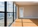 Bright living room with hardwood floors, a large window, and a door to an outdoor balcony space at 1280 W Peachtree St Nw # 3208, Atlanta, GA 30309