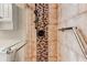 Close-up of a luxurious shower featuring glass door, mosaic tile accent stripe and safety handrail at 1280 W Peachtree St Nw # 3208, Atlanta, GA 30309