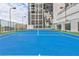 Bright blue tennis court with green accents, surrounded by a fence and modern building at 1280 W Peachtree St Nw # 3208, Atlanta, GA 30309