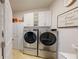 Laundry room with front load washer and dryer, storage cabinets, and a utility sink at 3311 Lindenridge Dr, Buford, GA 30519
