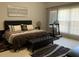 Comfortable main bedroom with a cushioned bench, decorative pillows, and an exercise machine at 3311 Lindenridge Dr, Buford, GA 30519