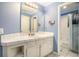 A bright bathroom features blue walls, a white vanity, and a convenient shower-tub combination at 3740 Cannonwolde Dr, Snellville, GA 30039