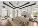 Main bedroom with ceiling fan, tray ceiling, and sitting area with large windows at 6272 Cheatham Lake Nw Dr, Acworth, GA 30101