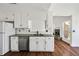 Galley kitchen with white cabinets, stainless appliances, and wood-look floors at 6272 Cheatham Lake Nw Dr, Acworth, GA 30101