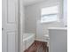 Bathroom with wood-look flooring, a tub, a window, and a vanity at 8523 Duncan St, Douglasville, GA 30134