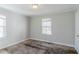 Bedroom featuring carpet, two windows, and white painted walls and trim at 8523 Duncan St, Douglasville, GA 30134