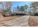 Long driveway leading to a beautiful home surrounded by mature trees and lush landscaping at 123 Creek Cir, Stockbridge, GA 30281