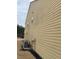 Home exterior featuring tan siding, trimmed windows, and a modern air conditioning unit at 1366 Image Xing, Lawrenceville, GA 30045