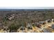 An aerial view of a neighborhood nestled among trees and hills under a blue sky at 139 Stargaze Rdg, Canton, GA 30114