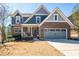 Charming brick and blue two-story home with a well-manicured lawn and two-car garage at 139 Stargaze Rdg, Canton, GA 30114