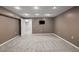 Finished basement area with neutral carpet and a television mounted on the wall at 1434 Blackland Trl, Lawrenceville, GA 30043