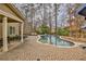 Lush backyard with a sparkling pool, brick patio, and mature trees, creating a private retreat at 2998 Octavia Cir, Marietta, GA 30062