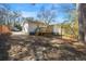 A home's backyard with a deck is surrounded by towering trees on a sunny day at 3687 Venus Nw Pl, Atlanta, GA 30331