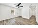 An empty room with gray floors, white walls, one window, ceiling fan and a white door at 3687 Venus Nw Pl, Atlanta, GA 30331