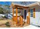 Close-up of wood porch with gray siding, wooden windows, and a blue door at 3687 Venus Nw Pl, Atlanta, GA 30331