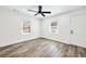 An empty room with gray floors, white walls, two windows, ceiling fan and a white door at 3687 Venus Nw Pl, Atlanta, GA 30331