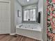 Relaxing bathroom with a soaking tub, window, and stylish shower curtain at 5228 Boone Ct, Villa Rica, GA 30180