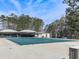 Large community pool covered for the off-season, surrounded by mature trees and sitting areas at 5228 Boone Ct, Villa Rica, GA 30180