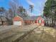 Traditional brick home with a two-car garage and a cozy front porch seating area at 5228 Boone Ct, Villa Rica, GA 30180