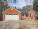 Charming brick home featuring an attached garage and manicured front lawn at 5228 Boone Ct, Villa Rica, GA 30180
