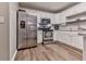 Modern kitchen featuring white cabinets, stainless steel appliances, and wood-look floors at 5228 Boone Ct, Villa Rica, GA 30180