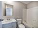 Neutral bathroom featuring tub-shower combination, single sink vanity with white marble countertop, and a framed mirror at 62 W Lakeview Dr, Temple, GA 30179
