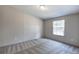 A bedroom with neutral walls and carpeted floors, showcasing a window with natural light at 62 W Lakeview Dr, Temple, GA 30179